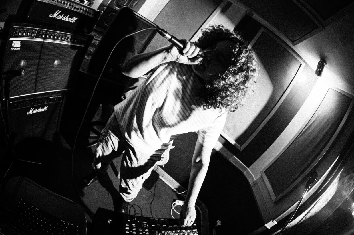 CHEEN singing into a microphone in the studio